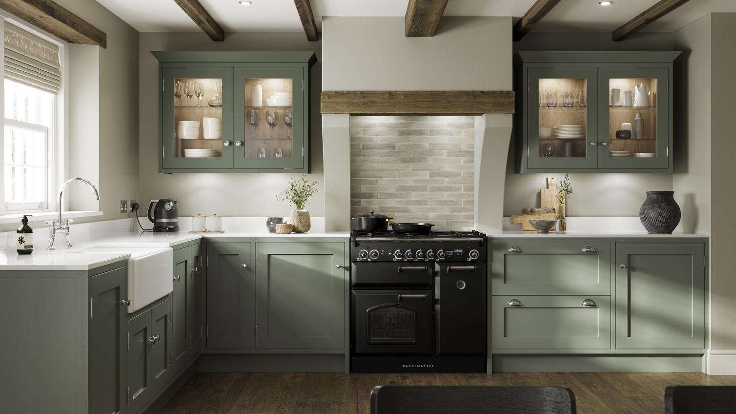 A reed green kitchen design in an open-plan layout with dark wood floors, shaker doors, a range cooker, and a ceramic sink.